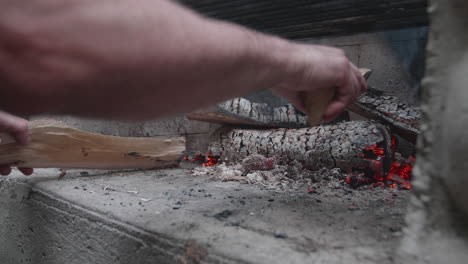 Hands-adjusting-woods-in-a-campfire