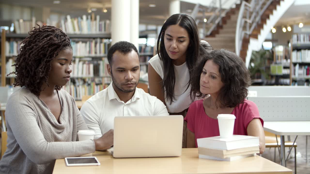 jóvenes concentrados leyendo información de la computadora portátil