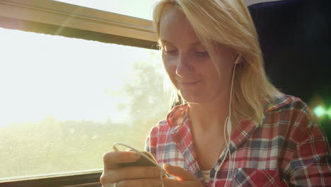 young woman on a train using a cellphone