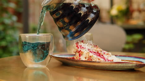pouring tea over a cake in a cafe