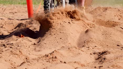 motorcyclist navigating sandy terrain and obstacles