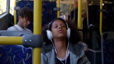 girl listening music on headphones while travelling in bus 4k