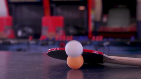 rebotando una pelota de ping pong y un bate rojo en una mesa de ping-pong en una sala de juegos arcade