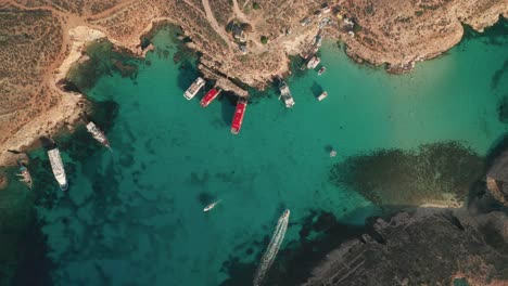 bird's eye drone view of malta's breathtaking blue lagoon, renowned for its turquoise and crystal-clear water surrounded by rugged rocks