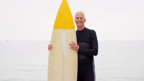 mature man holding surfboard