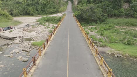 aerial forward over bridge of old road connecting la romana to higuey, chavon river in dominican republic