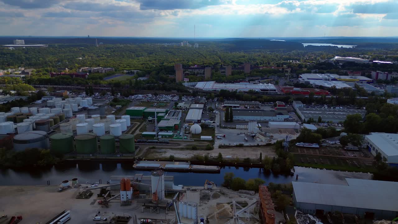 Berlin biogas plant with storage tanks by Spree river, producing renewable energy. Spectacular aerial view flight panorama overview drone