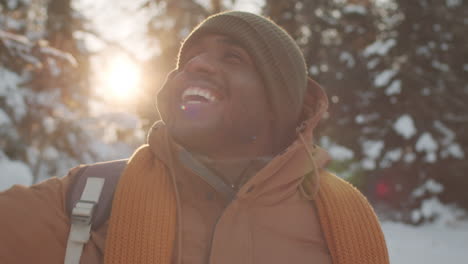 happy man hiking in snowy forest