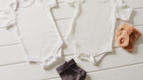 video of close up of two white baby grows with socks on white background