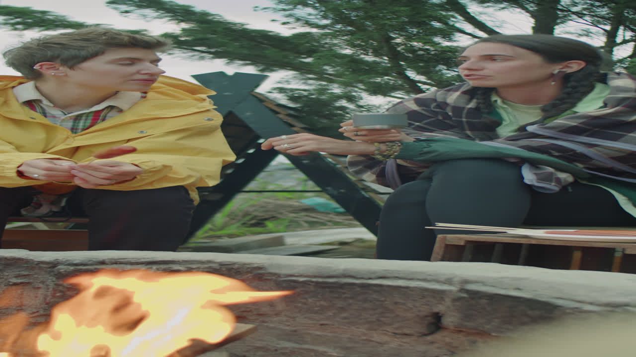 Female Friends Having Talk by Campfire