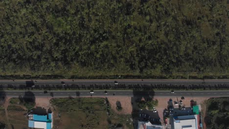 Droneshot-moving-over-a-highway-and-over-the-surrounding-forested-landscape
