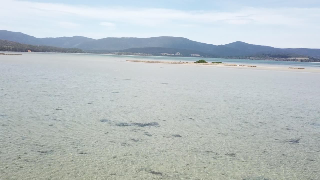 Rotating done footage over shallow water mountains in background