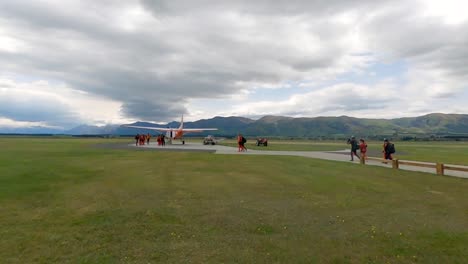 group of people boarding a small plane in a scenic mountain landscape