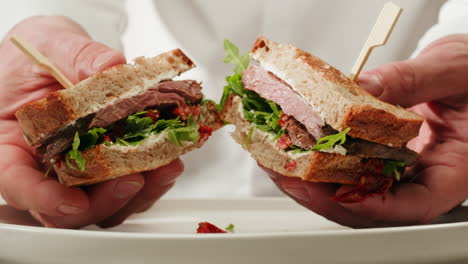 chef holding a gourmet sandwich