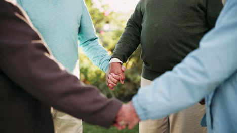 group of seniors holding hands in a garden