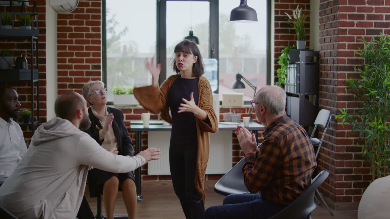 Vred kvinde forklarer psykiske problemer til terapeut og folk i en AA-gruppeterapi