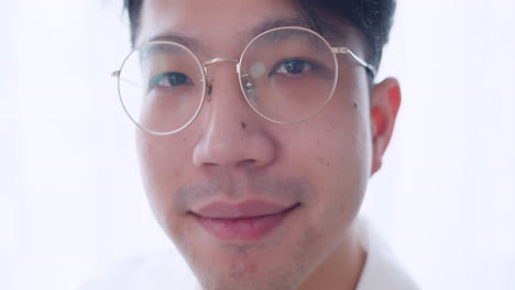 Close-up-Asian-man-with-glasses-and-healthy-good-hair-looking-to-the-camera-and-spoiling-himself-by-tidying-his-hair