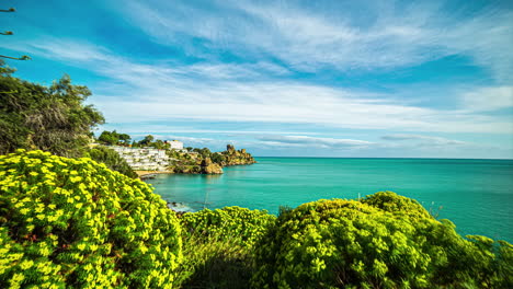 Static-shot-of-Rocca-di-Cefalù,-an-ancient-fishing-village-in-Sicily,-Italy-during-springtime-surrounded-by-lush-green-vegetation-with-white-clouds-passing-by-in-timelapse