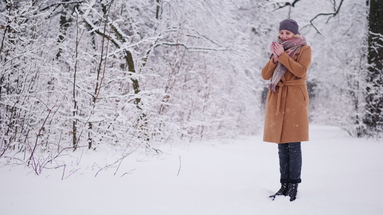 여자는 겨울 숲에서 뜨거운 차를 마신다
