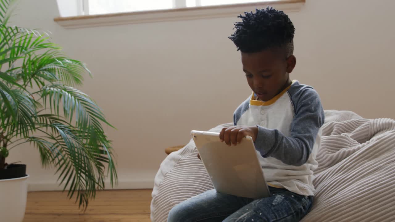 Boy using tablet computer at home