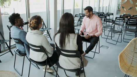 handsome bearded worker speaking to colleagues