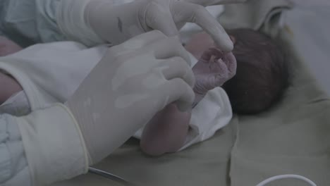 close-up putting on neonatal identification code bracelet for a newborn baby