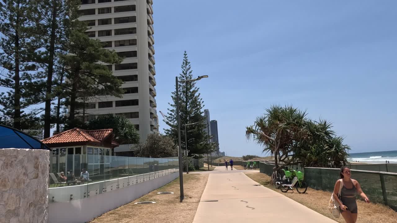 Pessoas aproveitando um dia ensolarado em um calçadão costeiro