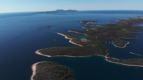 panorámica sobre muchas pequeñas islas croatas con un pequeño puerto y muchos barcos en el mar adriático