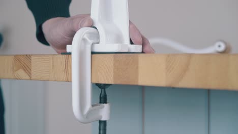 man fixes domestic flour grinder on wooden table closeup