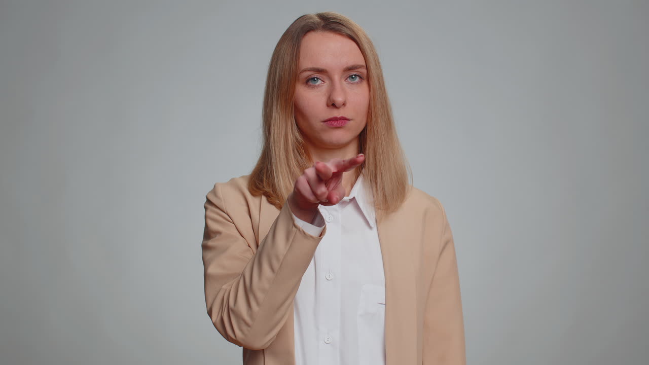 Business woman pointing at her eyes and camera show i am watching you gesture spying on someone