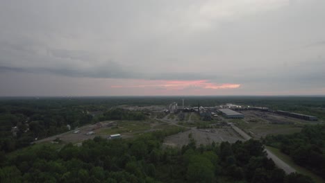 aerial drone forward moving shot over a large woodworking factory on a cloudy evening