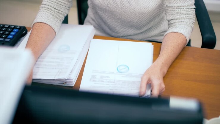 Woman in office working with documents. Quarterly report