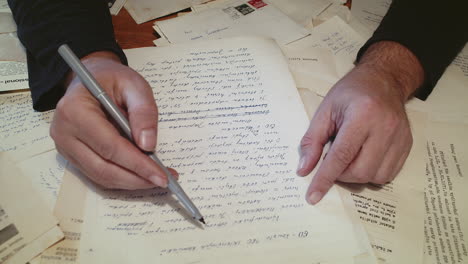 man checking documents and signing it using a pen on the office table