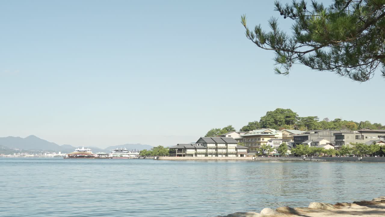 Itsukushima Island in Hiroshima captivates with its tranquil shoreline, vibrant greenery, and iconic cultural landmarks.
