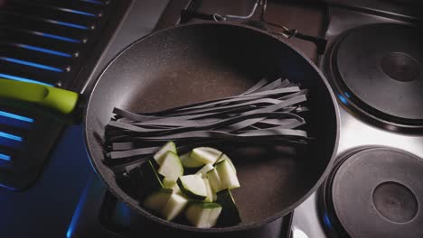 Tintenfischnudeln-Mit-Gemüse-Und-Tomatenpüree-In-Einer-Pfanne-Kochen