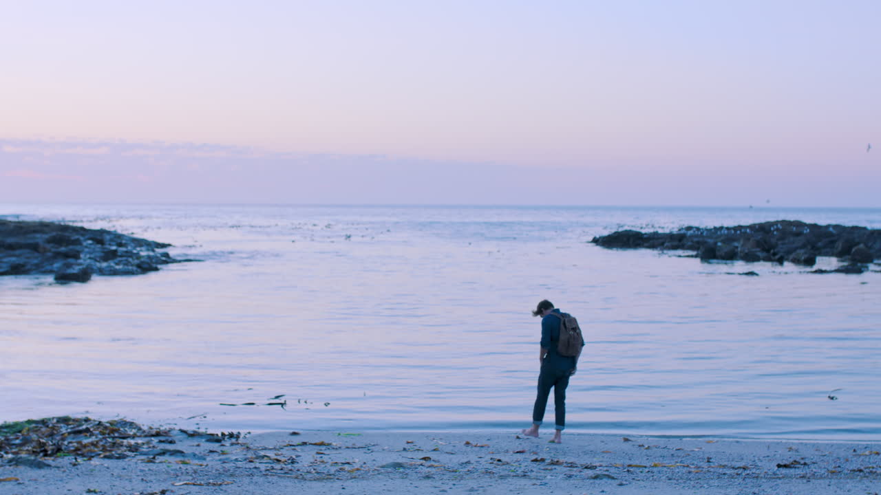 해변, 휴대폰, 그리고 바다의 사진을 찍는 남자