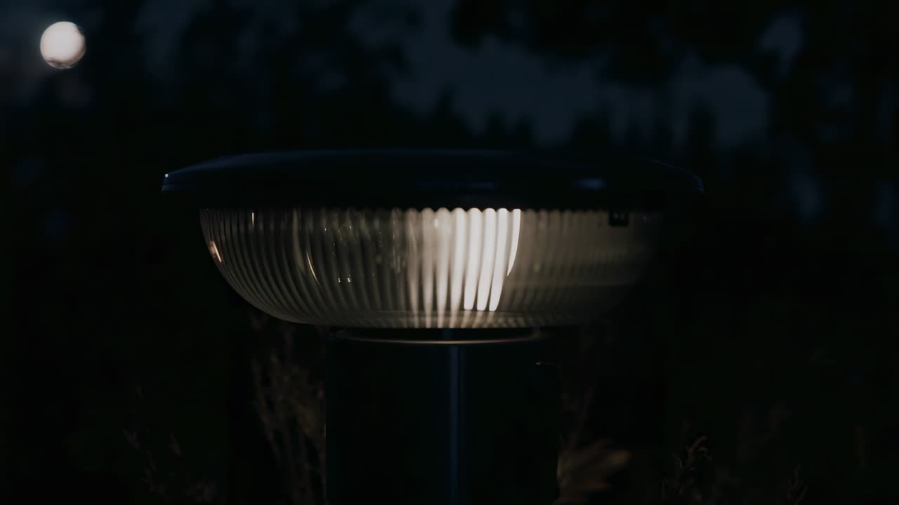 Konstant strøm holder pullertlampe glødende, flimrende mens den oplyser græsset til udendørs belysning