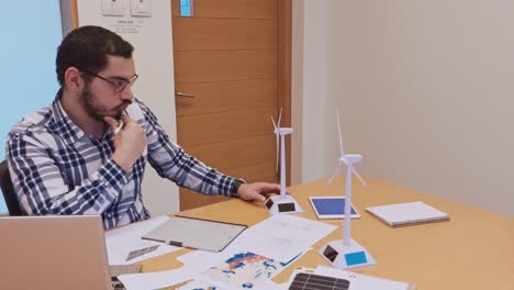 thoughtful engineer analyzing wind turbine model performance