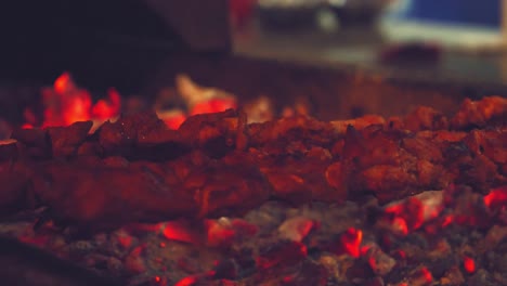 shish kebab on metal skewers being placed on hot red coal tray