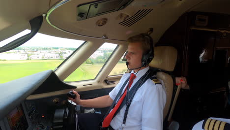 Male-pilot,-first-officer-in-cockpit-landing-a-jet-airplane,-hand-flying