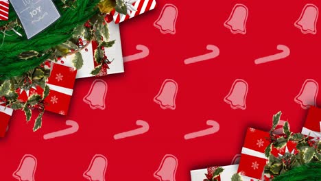 animation of christmas decorations and bells and candy canes pattern on red background