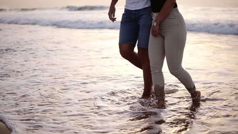 close up view video of man and woman walking bare feet at sandy beach by ocean. happy couple enjoying summer vacations at hot