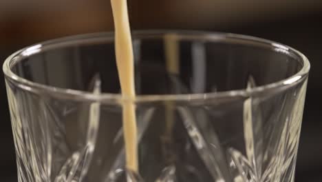 pouring a creamy drink into a glass