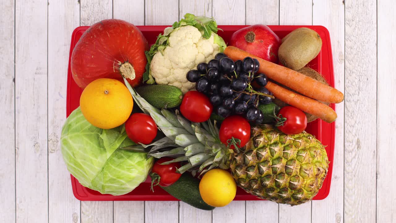Tray appear on wooden table and fruits and vegetables in tray. Stop motion