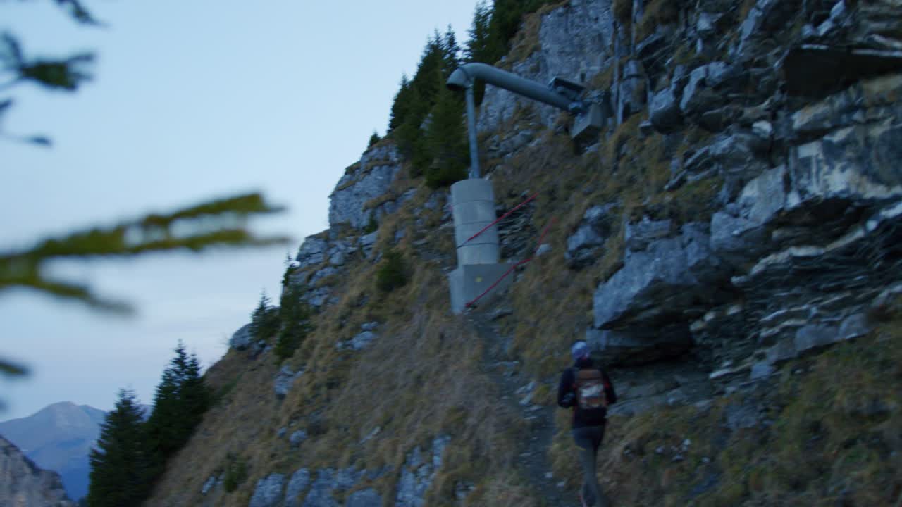 등산객이 절벽 아래의 좁은 길을 오르고 있다