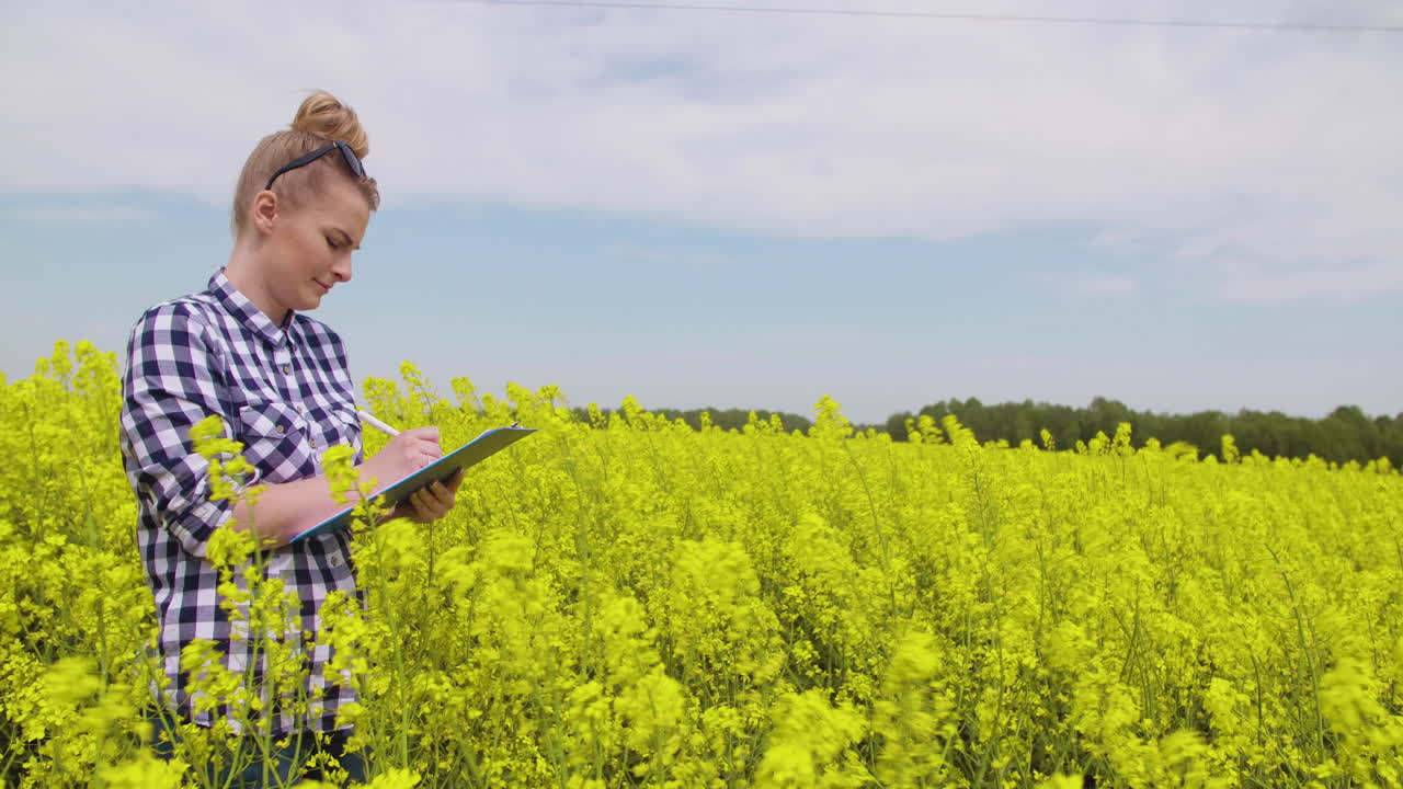feliz joven granjera en el campo de colza en flor