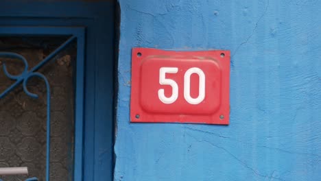 house number 50 on a blue wall