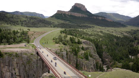 scenic mountain road and bridge over a deep canyon with vehicles