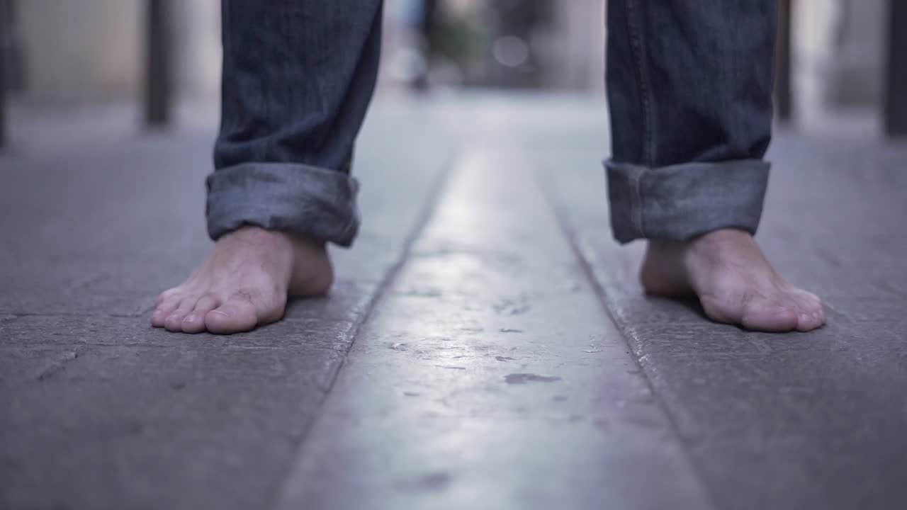 Barefoot Man and Traveler on the Street