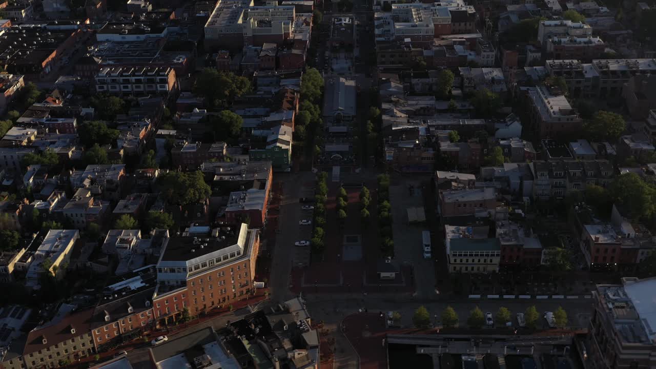 Aerial trucking tilt up to reveal Fells Point neighborhood in Baltimore Maryland at golden hour sunrise